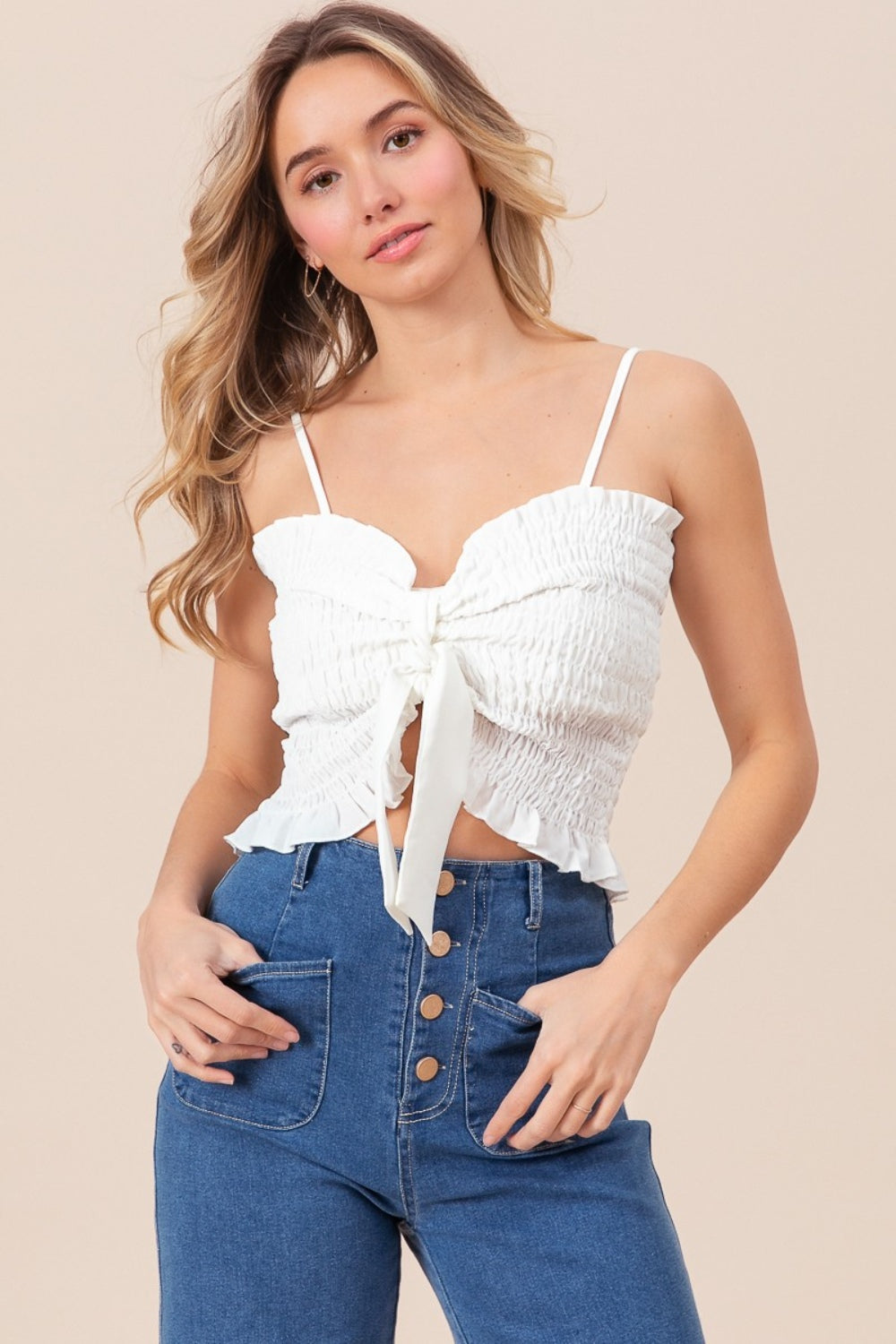 BiBi Ruffled Smocked Ribbon Detail CamiThe Ruffled Smocked Ribbon Detail Cami is a charming and feminine piece for your wardrobe. This cami features delicate ruffles, smocked detailing, and ribbon accents
