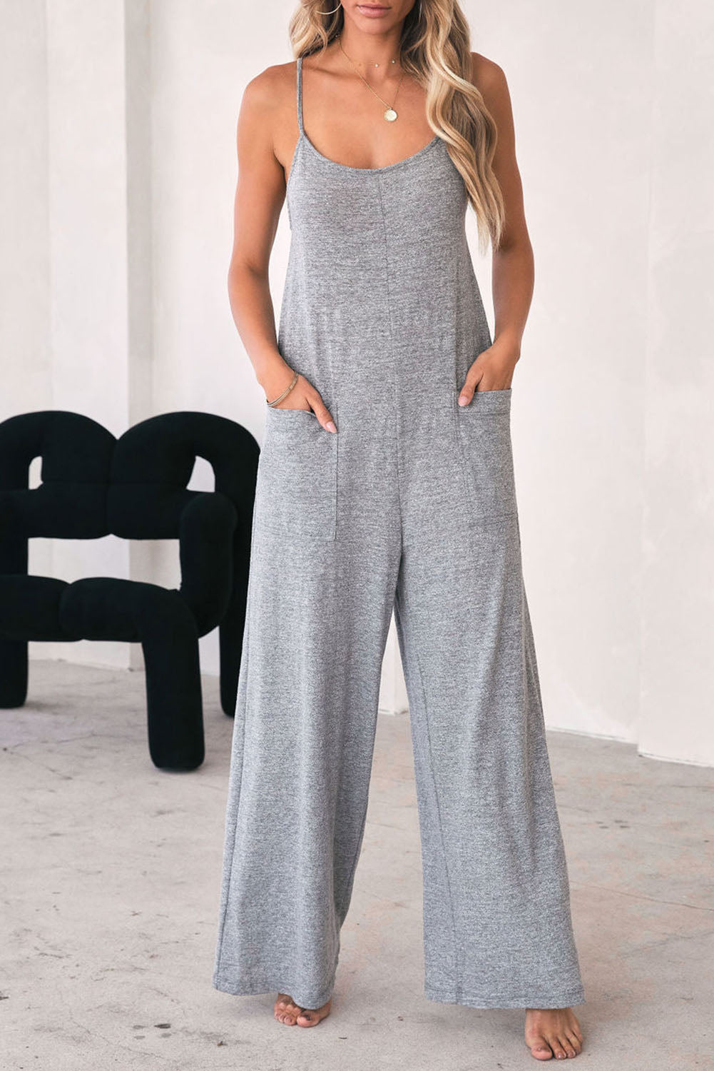 Gray Loose Fit Side Pockets Spaghetti Strap Wide Leg JumpsuitMaterial:65%Polyester+30%Cotton+5%Elastane



		Featuring a loose fit, the wide leg
jumpsuit provides freedom of movement
	
	
		Spaghetti straps highlight wome