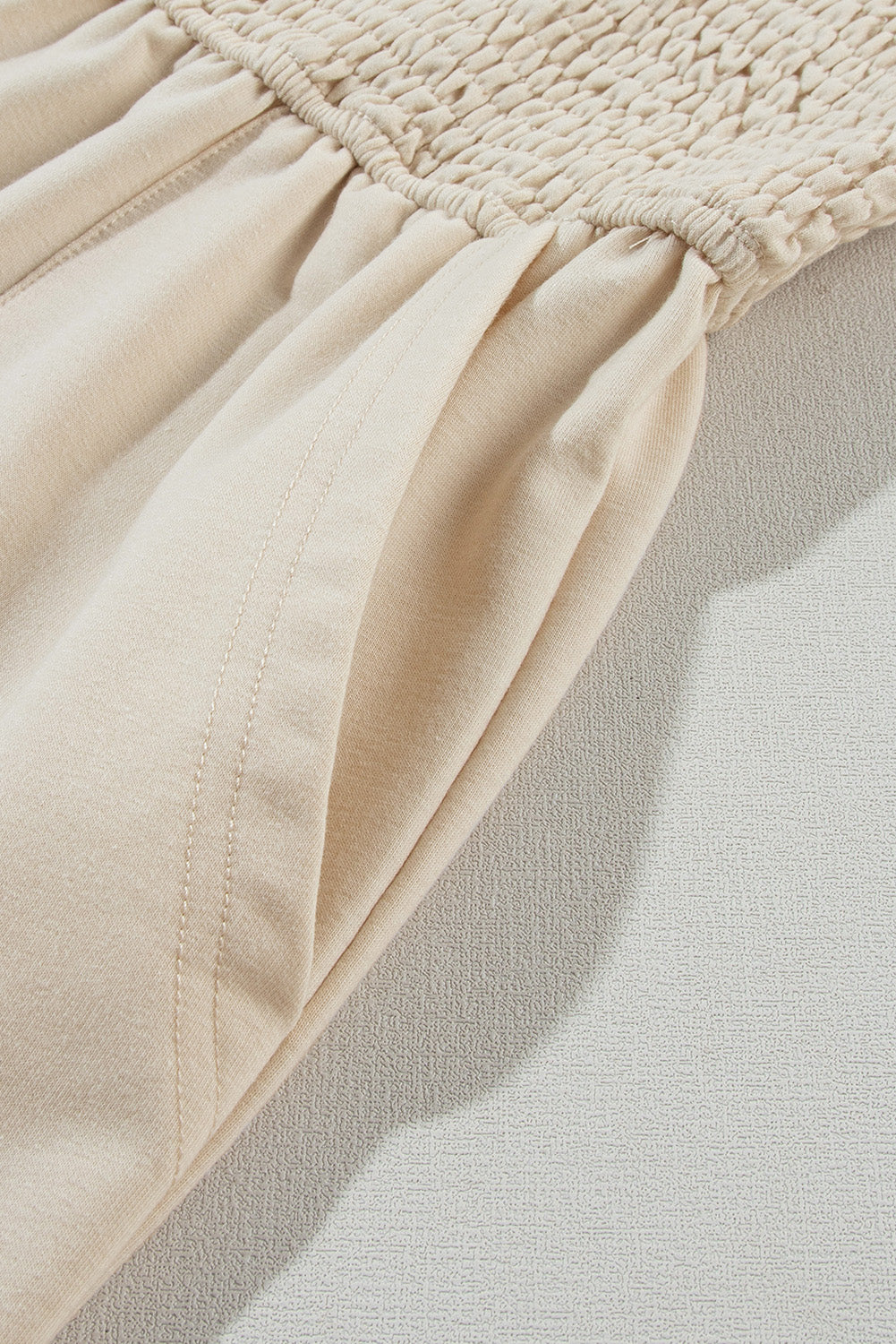 Beige Solid Color Buttons Smocked Sleeveless RomperMaterial:85%Polyester+10%Cotton+5%Elastane

• Its high waist design adds a flattering touch to any silhouette.
• Embrace the versatility of this romper with its sl