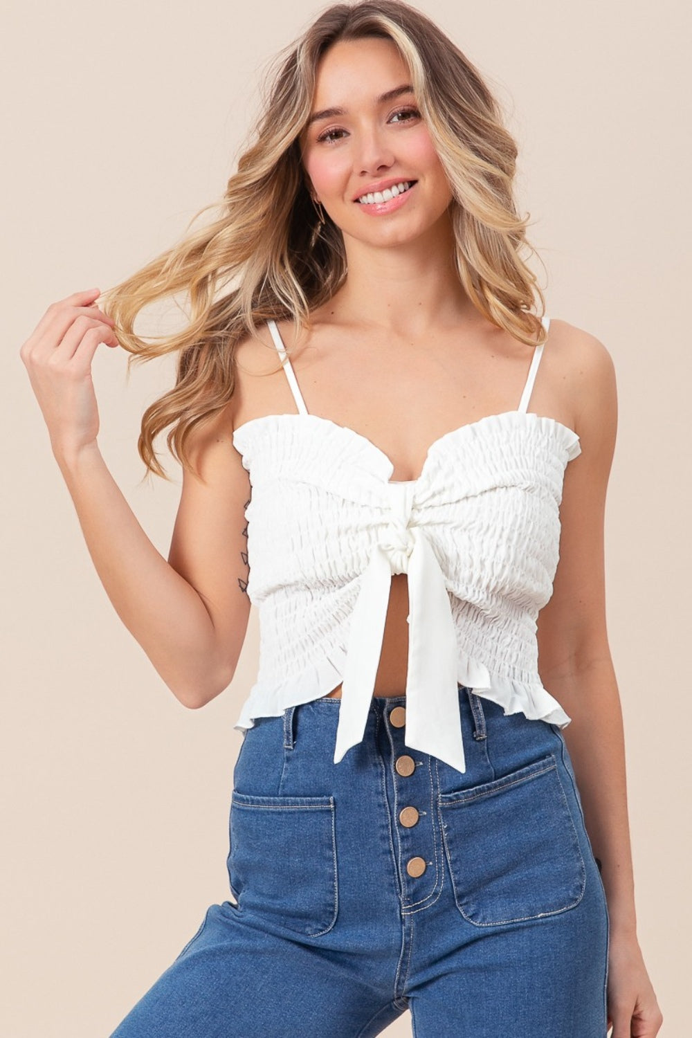 BiBi Ruffled Smocked Ribbon Detail CamiThe Ruffled Smocked Ribbon Detail Cami is a charming and feminine piece for your wardrobe. This cami features delicate ruffles, smocked detailing, and ribbon accents