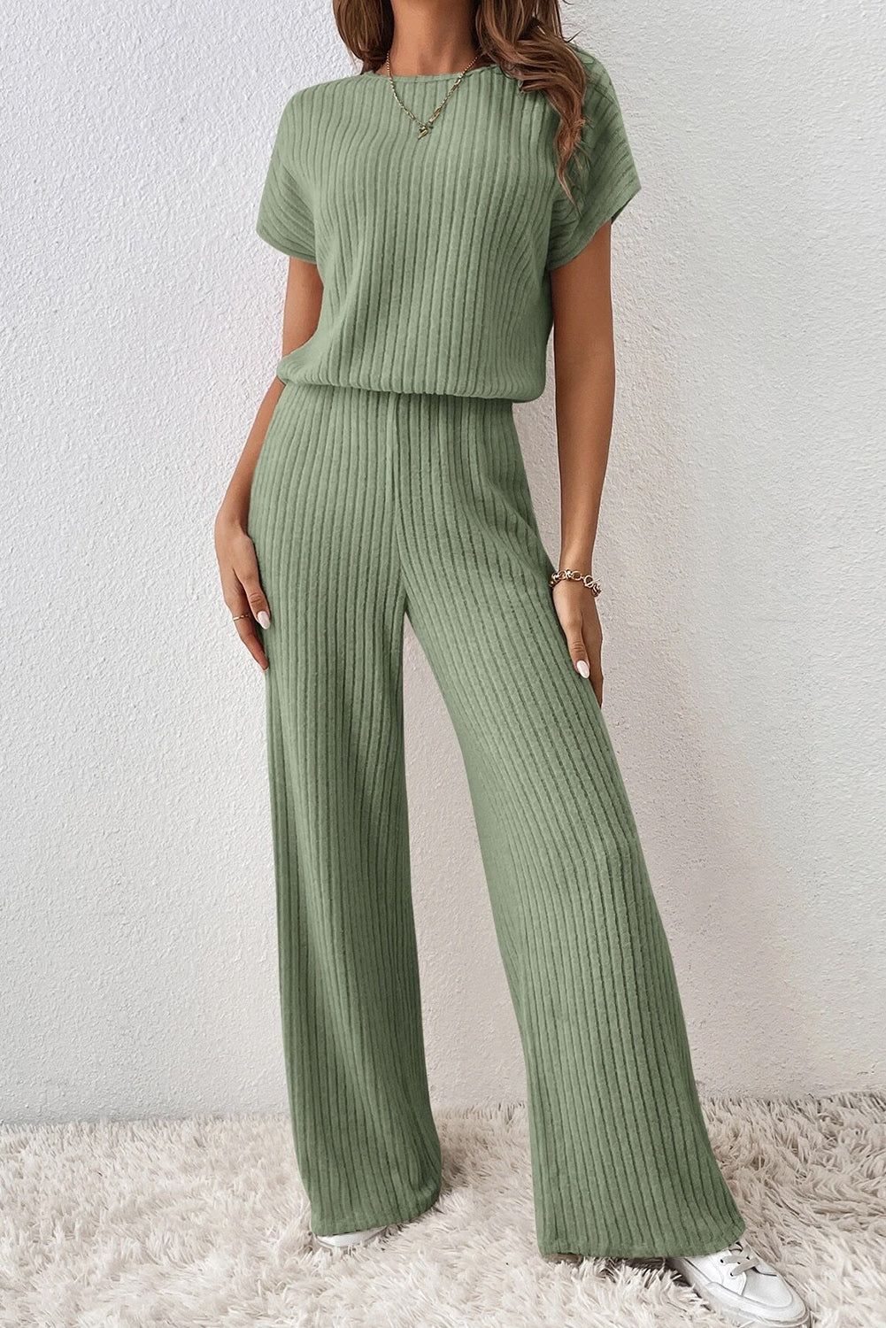 Grass Green Solid Color Ribbed Short Sleeve Wide Leg JumpsuitMaterial:85%Polyester+10%Viscose+5%Elastane



		The jumpsuit is a versatile and trendy one-piece outfit, featuring a solid color design that offers a sleek and mi