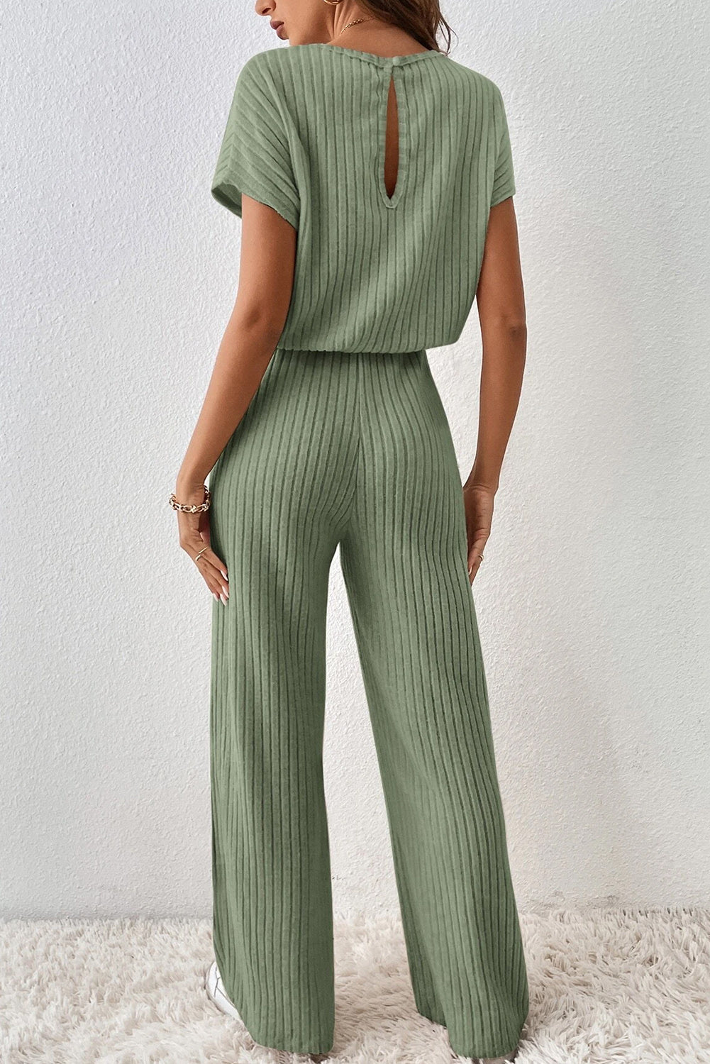 Grass Green Solid Color Ribbed Short Sleeve Wide Leg JumpsuitMaterial:85%Polyester+10%Viscose+5%Elastane



		The jumpsuit is a versatile and trendy one-piece outfit, featuring a solid color design that offers a sleek and mi