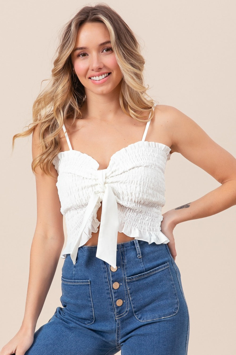 BiBi Ruffled Smocked Ribbon Detail CamiThe Ruffled Smocked Ribbon Detail Cami is a charming and feminine piece for your wardrobe. This cami features delicate ruffles, smocked detailing, and ribbon accents